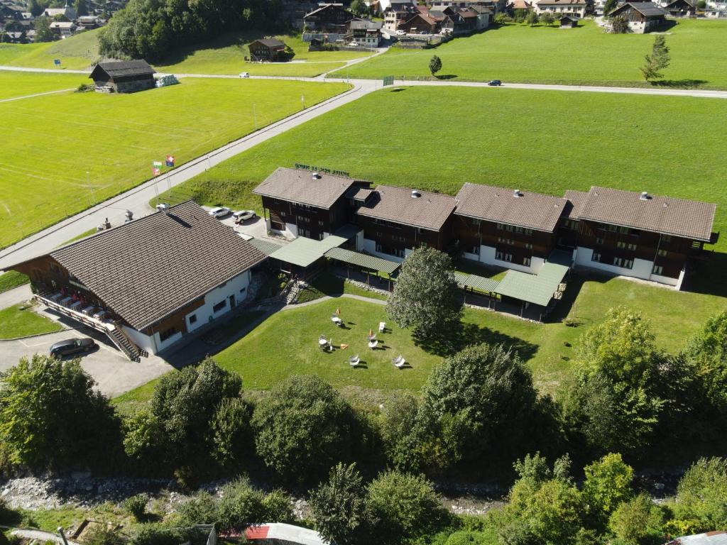 - une vue aérienne sur une maison avec une cour dans l'établissement Hotel Roc et Neige, à Château-d'Oex