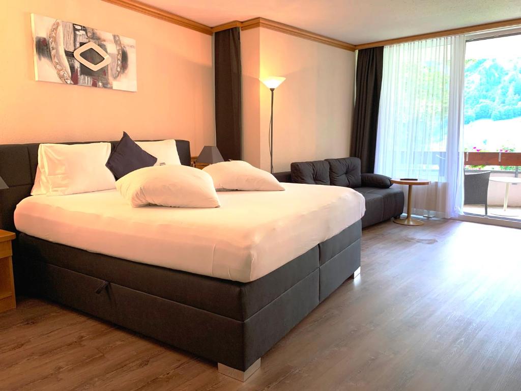 Postel nebo postele na pokoji v ubytování Hotel Quellenhof Leukerbad