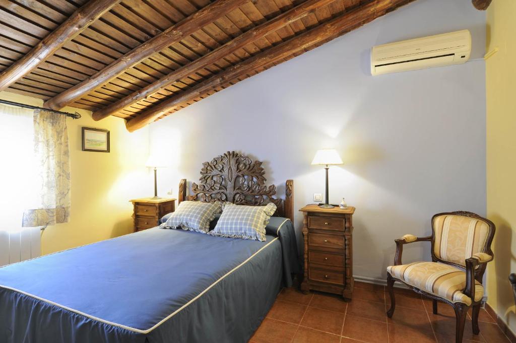 1 dormitorio con 1 cama azul y 1 silla en Valdexpacio, en Valdecaballeros
