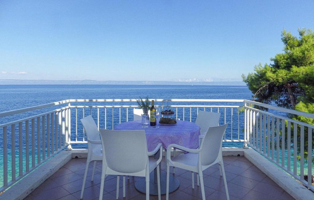 a table and chairs on a balcony with the ocean at Apartmani Pipin - Prigradica, kod Caffe Tempera in Prigradica