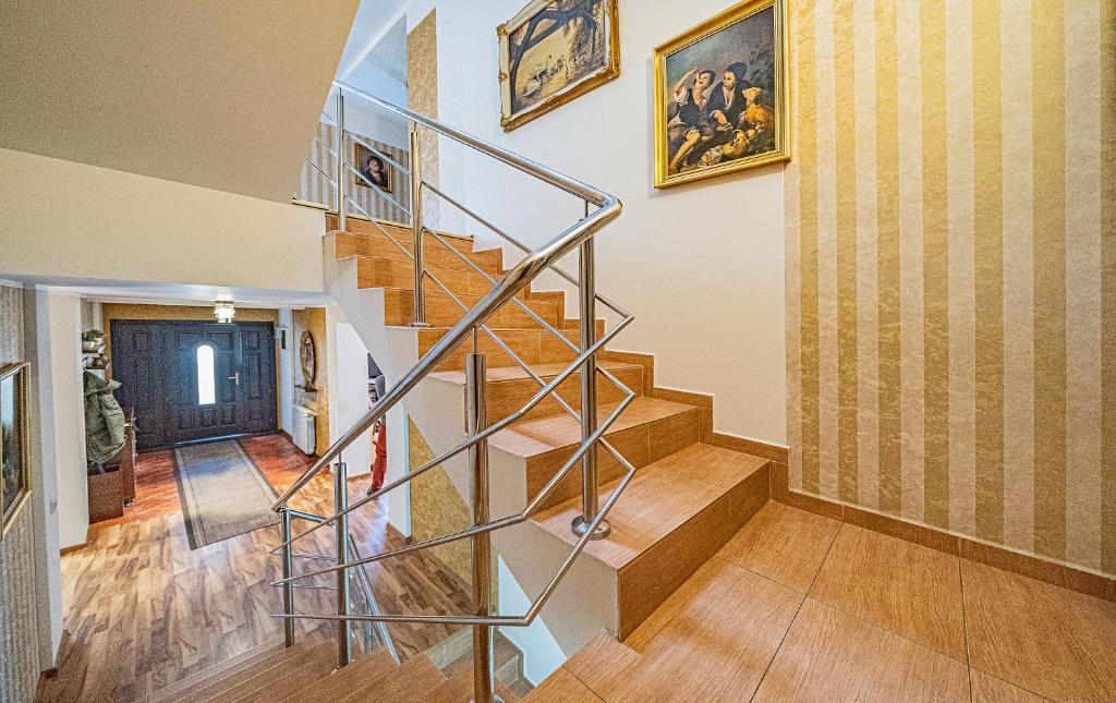 a spiral staircase in a home with paintings on the wall at Pension Onix Vienna Airport in Maria Ellend