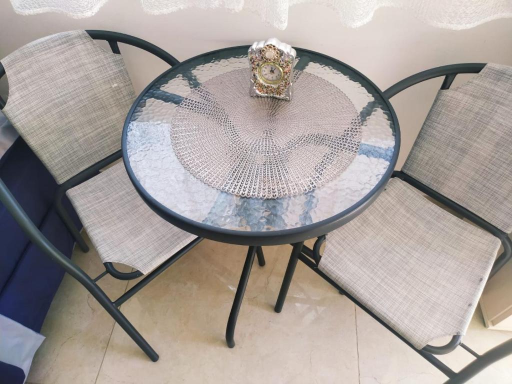 una mesa de cristal con una corona sobre dos sillas en Quiet place, en Beʼer Ora