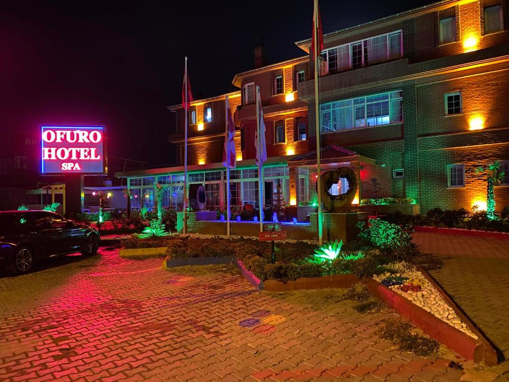 a building with a neon sign in front of it at OFURO WORLD HOTEL SPA in Izmir