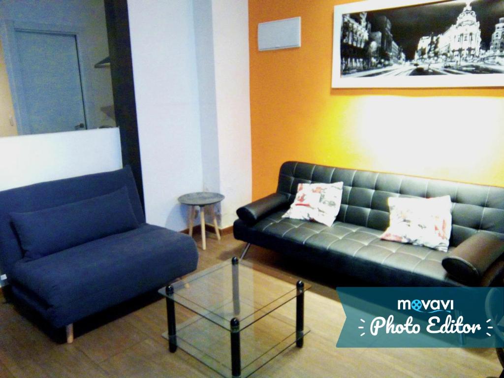 ein Wohnzimmer mit einem Sofa und einem Stuhl in der Unterkunft Z45 Loft con Wifi en el Madrid Centro in Madrid