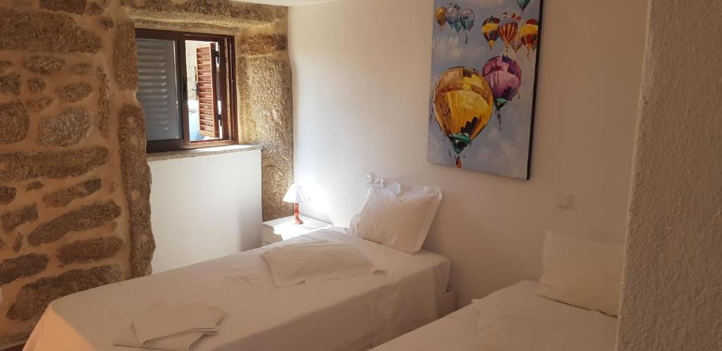 a bedroom with two white beds and a window at Casa Dr. Saba in Belmonte