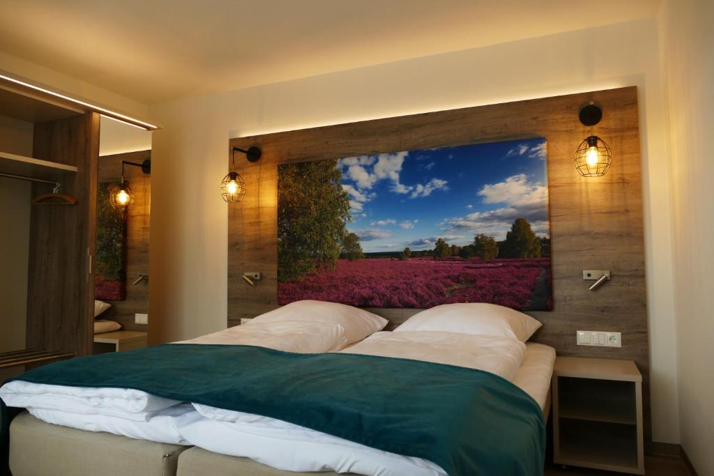 a bedroom with a large painting on the wall at Meyn's Apartments & Hotel in Soltau