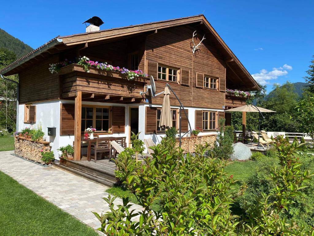 ein Holzhaus mit einer Veranda und einer Terrasse in der Unterkunft Chalet Tirolia in Kirchdorf in Tirol