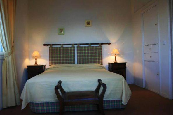 um quarto com uma cama grande e 2 candeeiros nas mesas em Corfu Aegli appartments em (( Filaréton ))