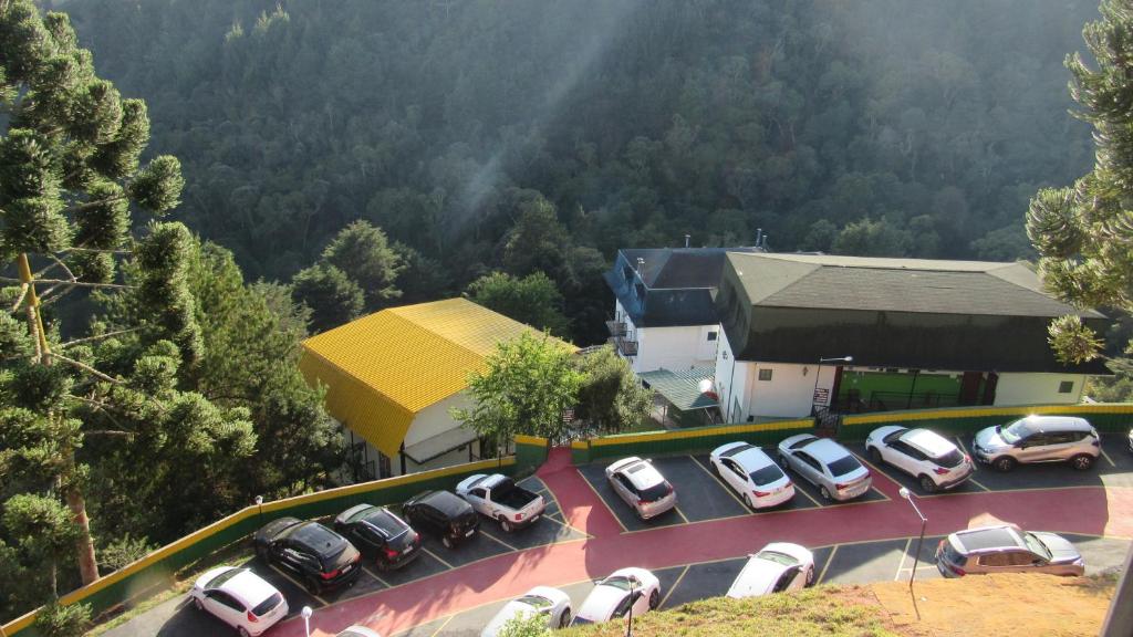 Um monte de carros estacionados num parque de estacionamento. em Golden Forest Pousada em Campos de Jordão