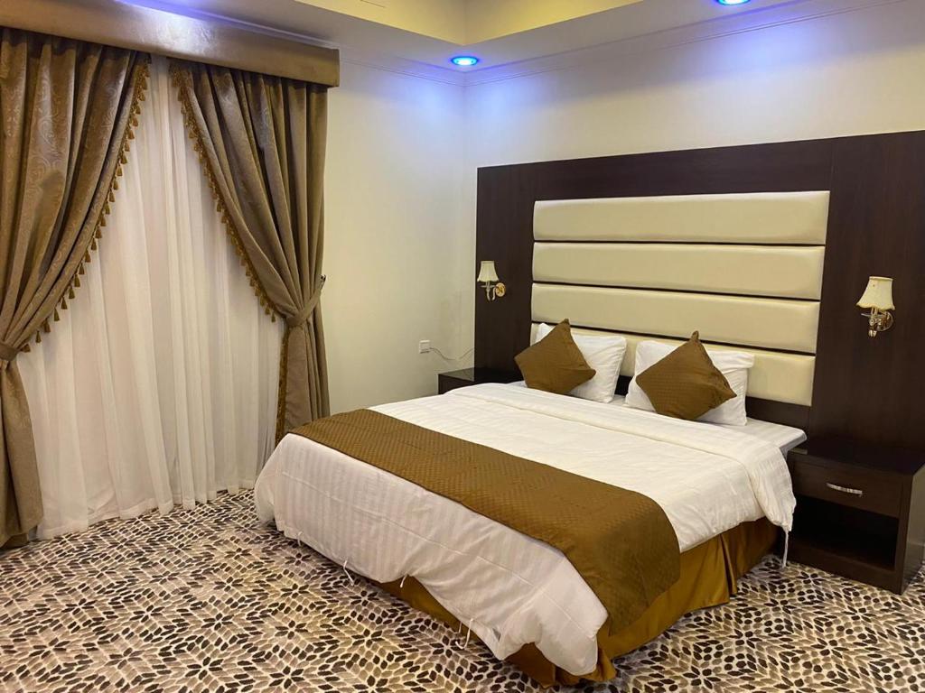 een slaapkamer met een groot bed in een kamer bij دانة الشرقية للشقق المخدومة بالدمام Danat Al Sharqiah Serviced Apartments in Dammam