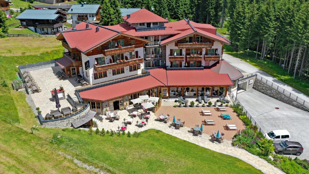 einen Luftblick auf ein großes Haus mit einer Terrasse in der Unterkunft Berghotel Der Königsleitner - Adults only in Königsleiten