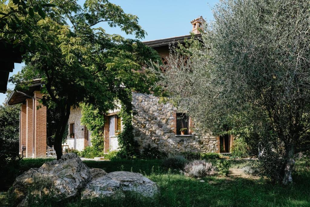 une maison en pierre avec un arbre en face de celle-ci dans l'établissement Adagio House, à Valdamonte