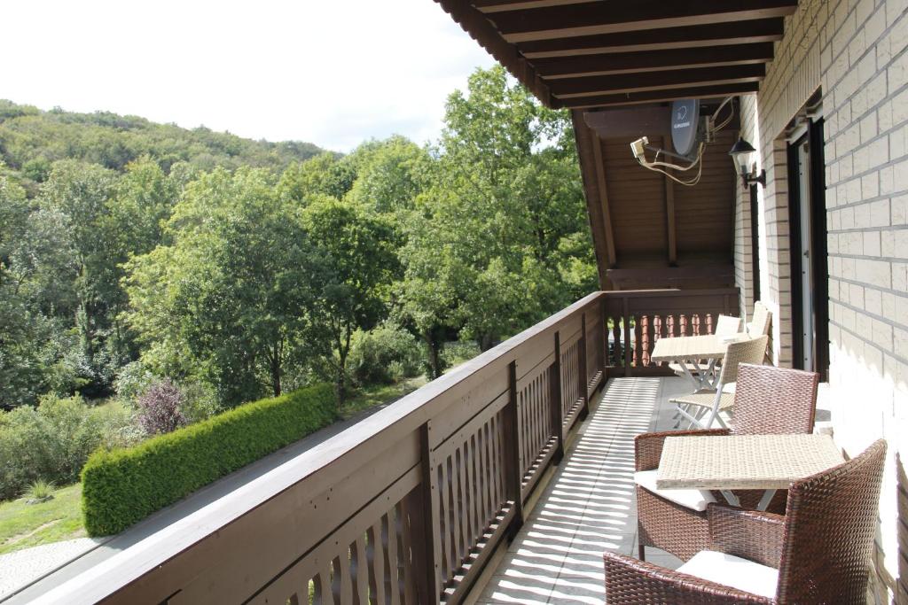 Un balcón con sillas y mesas en una casa en Ferienwohnug Zur alten Eiche, en Bad Endbach