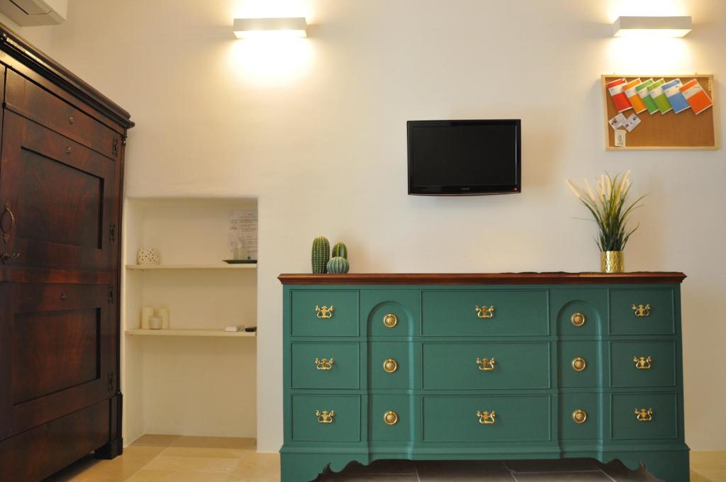 Vestidor verde con TV en la pared en Casetta Elilù, en Ostuni