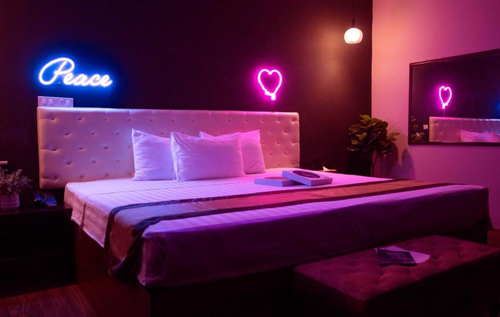 My Hotel 23 في هانوي: غرفة نوم مع سرير مع أضواء نيون عليه