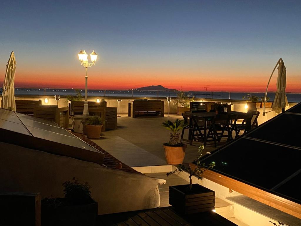 eine Terrasse mit einem Tisch und einer Straßenbeleuchtung bei Sonnenuntergang in der Unterkunft La Pennichella Sorrentina Relais in Meta