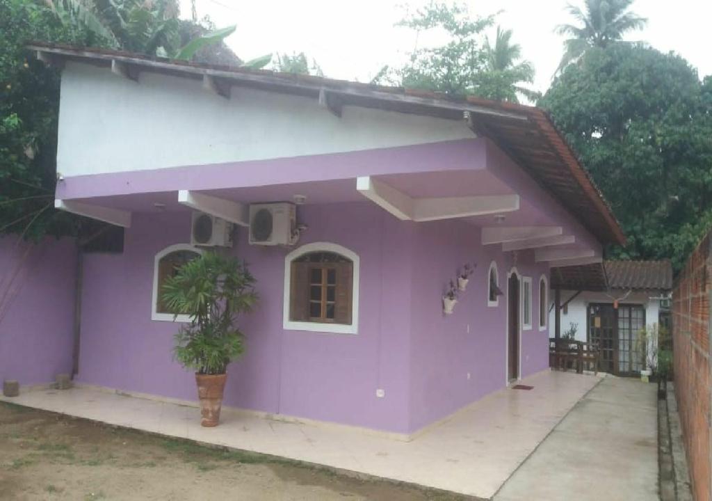 a purple house with a plant in front of it at Casacurral in Ilhabela