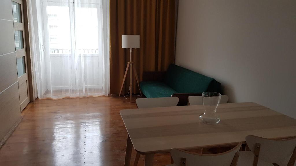 ein Wohnzimmer mit einem Tisch und einem grünen Sofa in der Unterkunft Sienkiewicza Centrum in Kielce