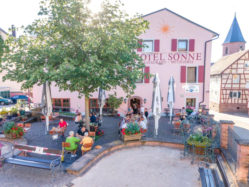 un grupo de personas sentadas fuera de un edificio en Hotel - Restaurant - Metzgerei Sonne, en Loffenau