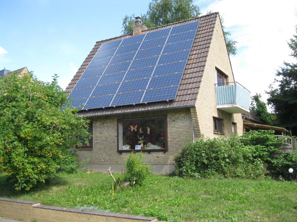 ein Haus mit vielen Sonnenkollektoren auf dem Dach in der Unterkunft Ferienwohnung ULLABRU in Ascheffel