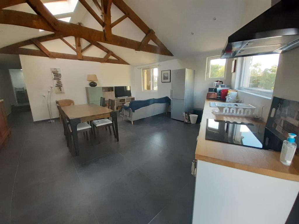 une cuisine et un salon avec une table et un canapé dans l'établissement Albizia rouge - Gîte de charme à la campagne, à Galgon