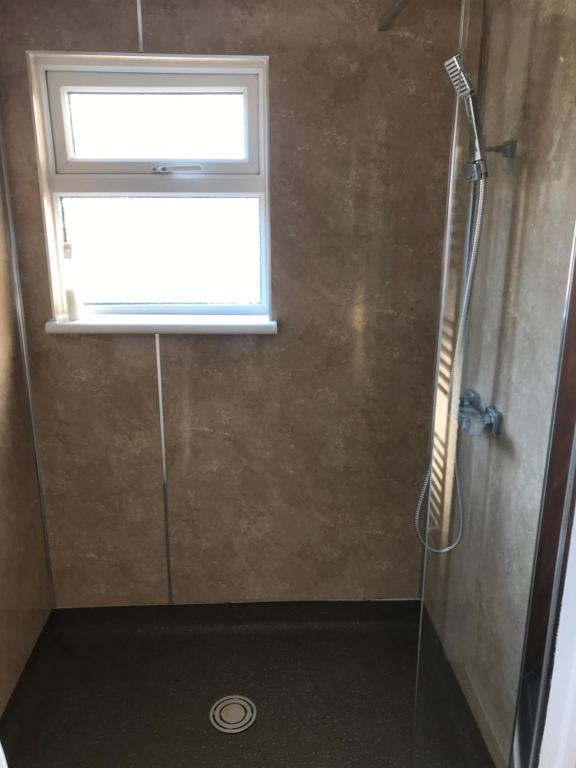 a bathroom with a shower with a window at Richmond Luxury flat Fabulous location in Southend-on-Sea