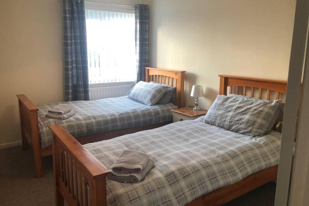 a bedroom with two beds and a window at Newton Aycliffe Contractors Accommodation in Newton Aycliffe