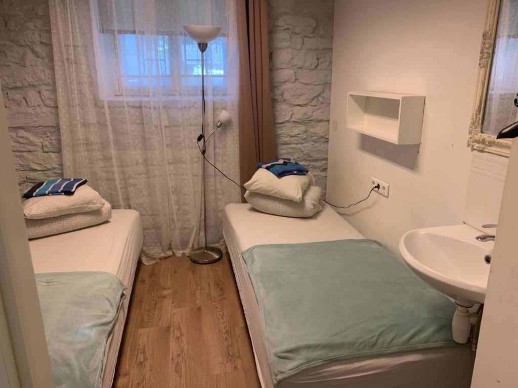 mały pokój z 2 łóżkami i umywalką w obiekcie Süda Hostel w Tallinnie