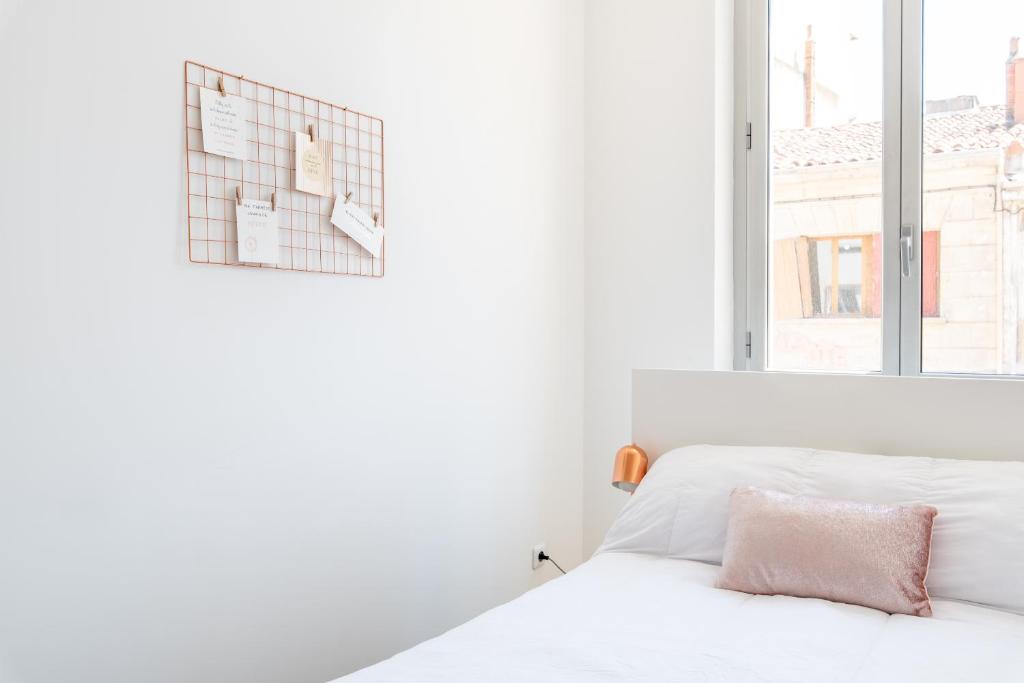 une chambre blanche avec un lit et une fenêtre dans l'établissement Le Cosy Blancarde -Appartement 1 chambre 4 pers- Clim Parking, à Marseille