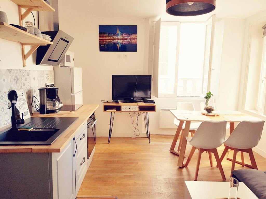Una cocina con una mesa y un comedor. en INTRAMUROS Charmant 30m2 rénové, en Saint-Malo