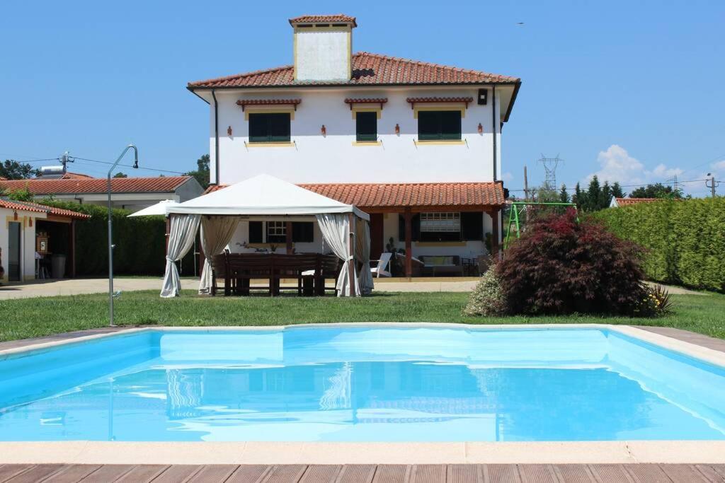 una gran piscina azul frente a una casa en CORVITINHO, en Guimarães