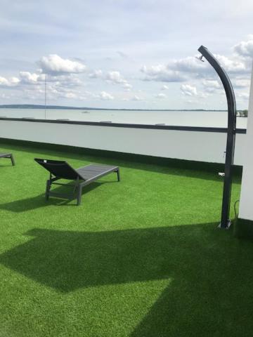 a bench sitting on the grass next to a building at Balatonparti Gyöngyszem in Keszthely