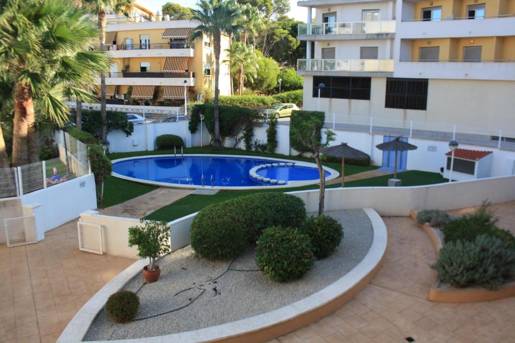 an apartment with a swimming pool and a building at Camalavi in Moraira