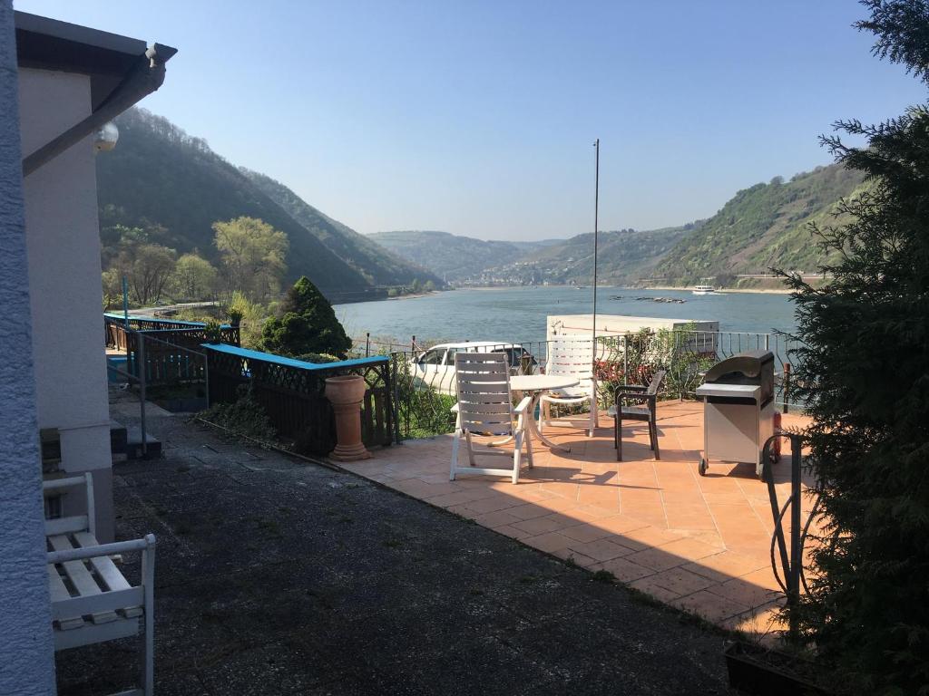a house with a patio with a view of a lake at Loreleybrunnen in Sankt Goarshausen