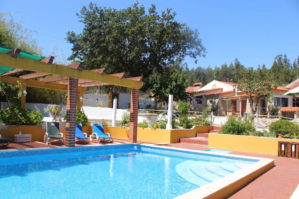 - une piscine dans une cour avec une maison dans l'établissement Casal do Varatojo, à Alcobaça