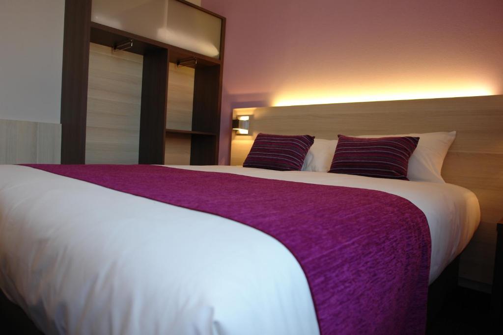 塞科斯的住宿－拉弗萊赫芙蓉布里特酒店，卧室配有一张白色大床、紫色床单和枕头