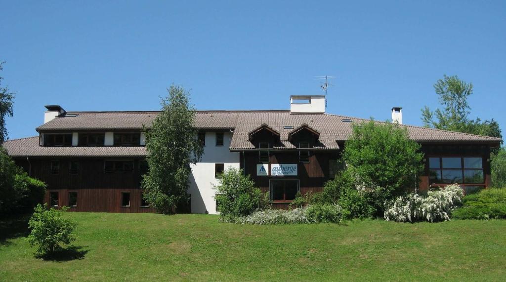 una casa grande con un patio verde delante de ella en Auberge de Jeunesse HI Annecy en Annecy