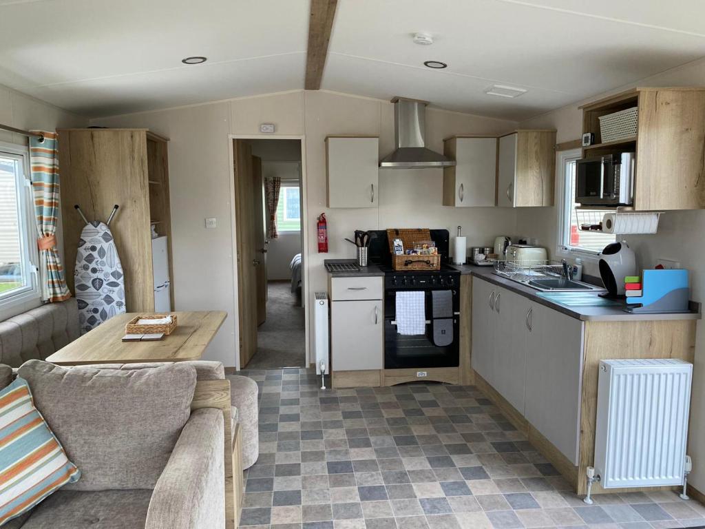 a kitchen and living room with a couch and a table at Caravan Porthcawl in Porthcawl