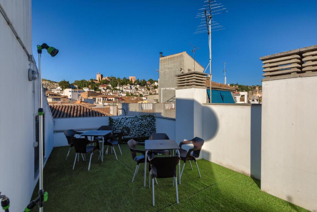 a balcony with tables and chairs on a building at H2Granada en Centro Terraza-solarium & Parking in Granada