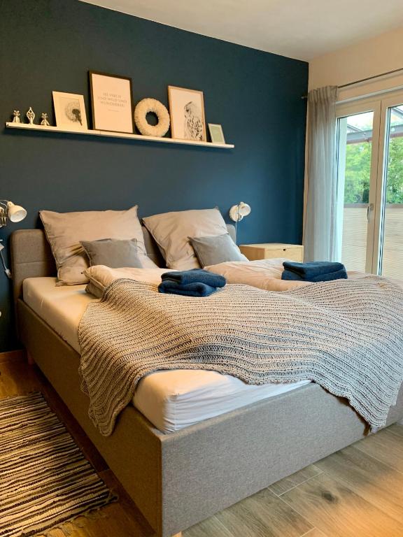 a bedroom with two beds and a blue wall at Laura‘s Heimat in Bad Bergzabern