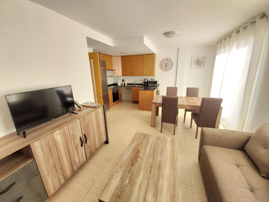 a living room with a television and a table with chairs at Apartamento a Torreblanca in Torreblanca