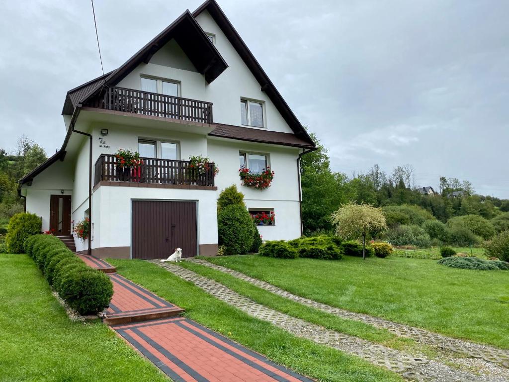 a white house with a balcony and a yard at Studio w Pieninach in Krościenko