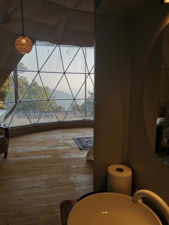 AlıncaにあるTürkdomes Glampingのバスルーム(トイレ付)、大きな窓が備わります。