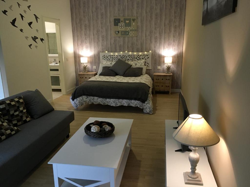 a bedroom with a bed and a couch and a table at Finca Casaes Apartamentos in Torralba de Oropesa