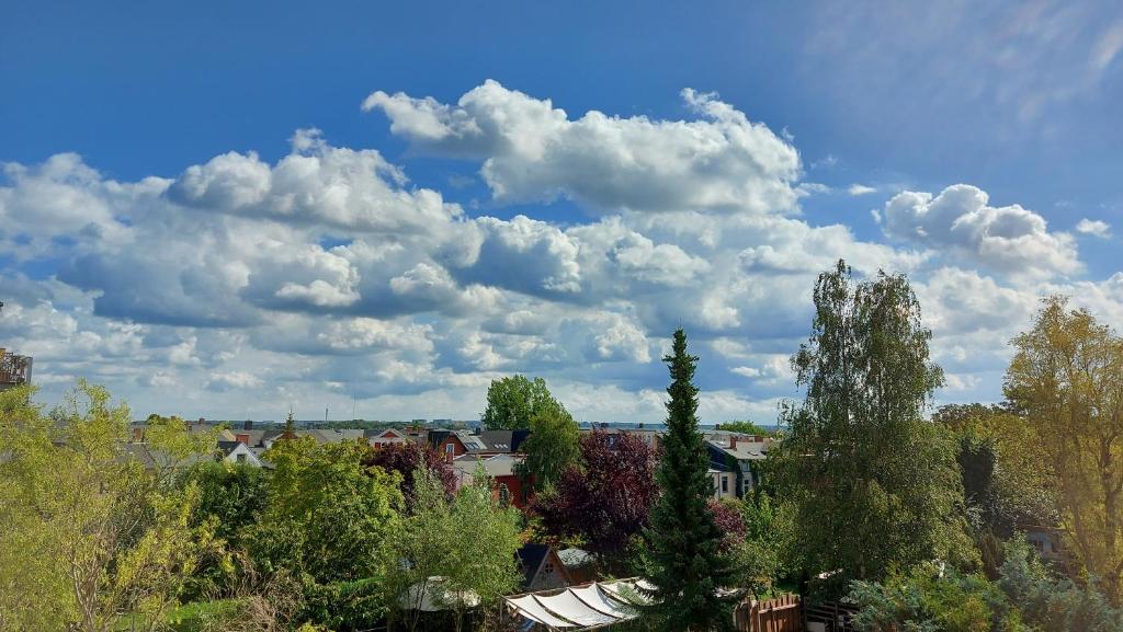 uma cidade com árvores e nuvens no céu em Von-Thünen em Schwerin