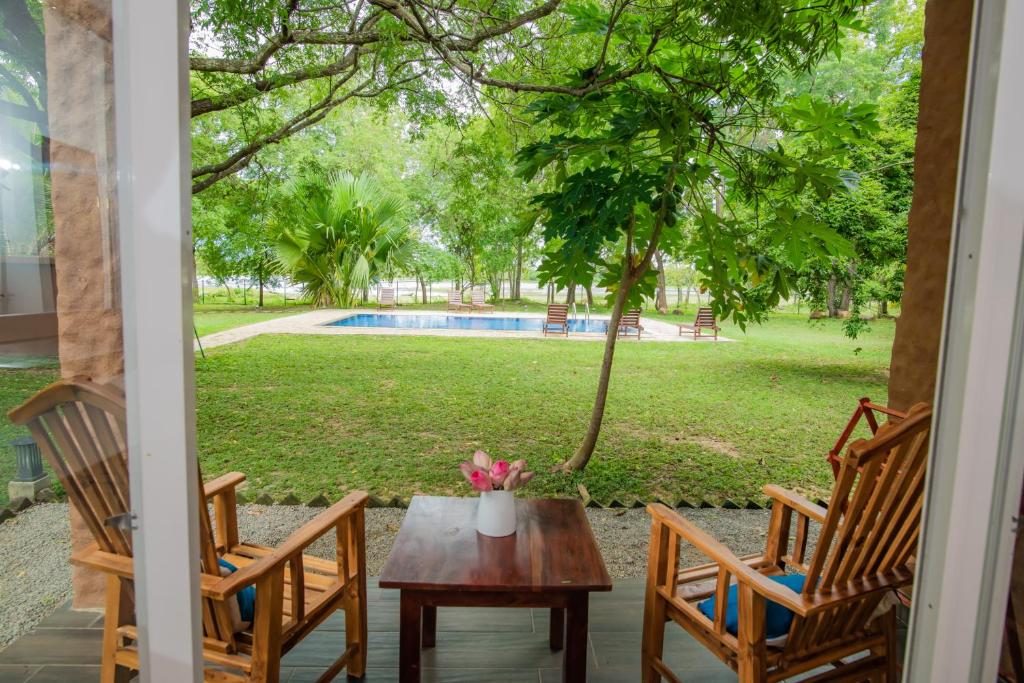 a porch with a table and chairs and a pool at Tranquil Wild in Tanamalwila
