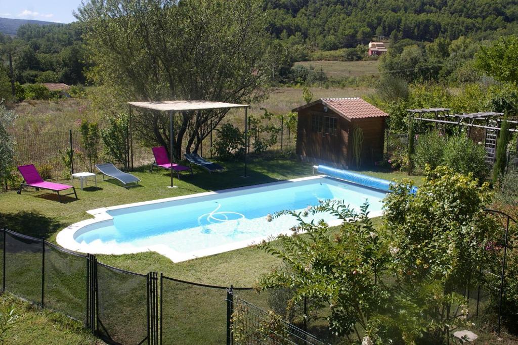 uma piscina num quintal com cadeiras roxas em IA ORANA em Gargas