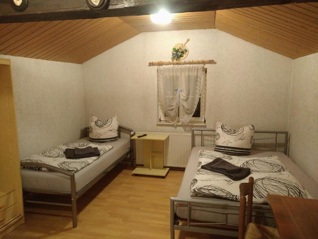 um quarto com duas camas e uma mesa e uma janela em Ferienhaus Börsengasse 1 em Duderstadt