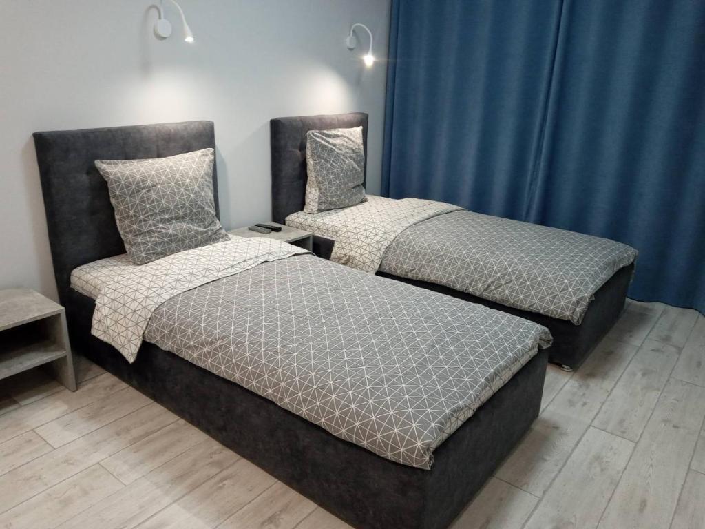 dos camas sentadas una al lado de la otra en una habitación en Посуточно отличная квартира в центре en Úzhgorod