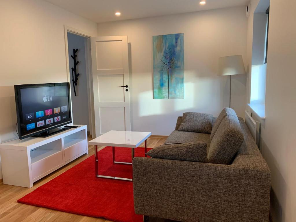 a living room with a couch and a flat screen tv at Field View B&B in Lund